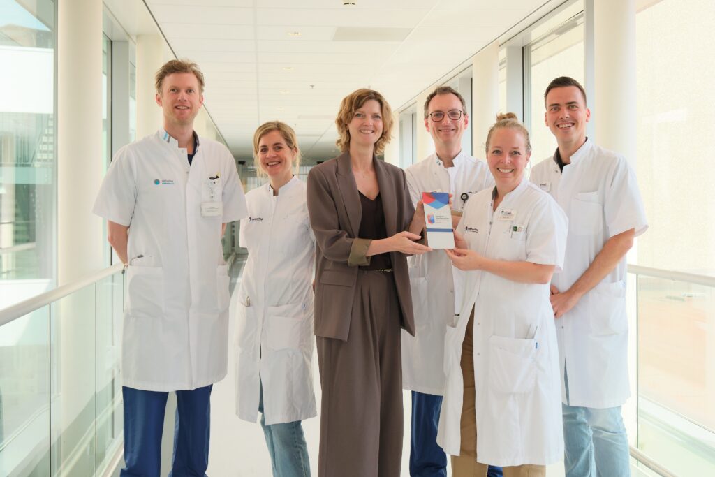 Viviane Dietz, lid Raad van Bestuur, overhandigt de erkenning aan Inge van Uden (tweede van rechts). Verder staan interventiecardioloog Pieter-Jan Vlaar, verpleegkundig specialist vasculaire neurologie Joska van Overbruggen, (interventie)radioloog Dennis Kies en verpleegkundig specialist Vasculaire Interne Geneeskunde Daan van de Bersselaar op de foto. Zij maken deel uit van het multidisciplinaire team Young Stroke. Internist Eveline Besselaar, cardioloog Pepijn van der Voort, radioloog Jorit van Rossen en revalidatiearts Ilse van den Brand ontbreken op de foto. Foto: Jarno Verhoef/Catharina Ziekenhuis