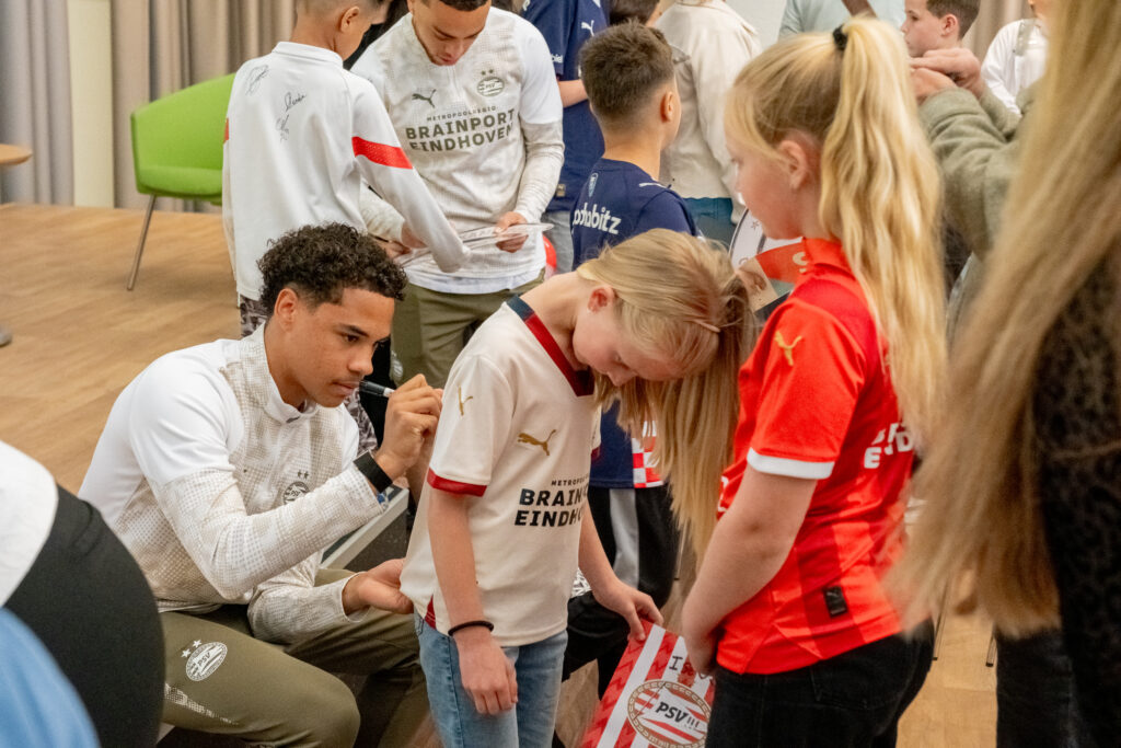 Noah Fernandez zet zijn handtekening op het shirt van Ise. Foto: Bas Smits/Catharina Ziekenhuis